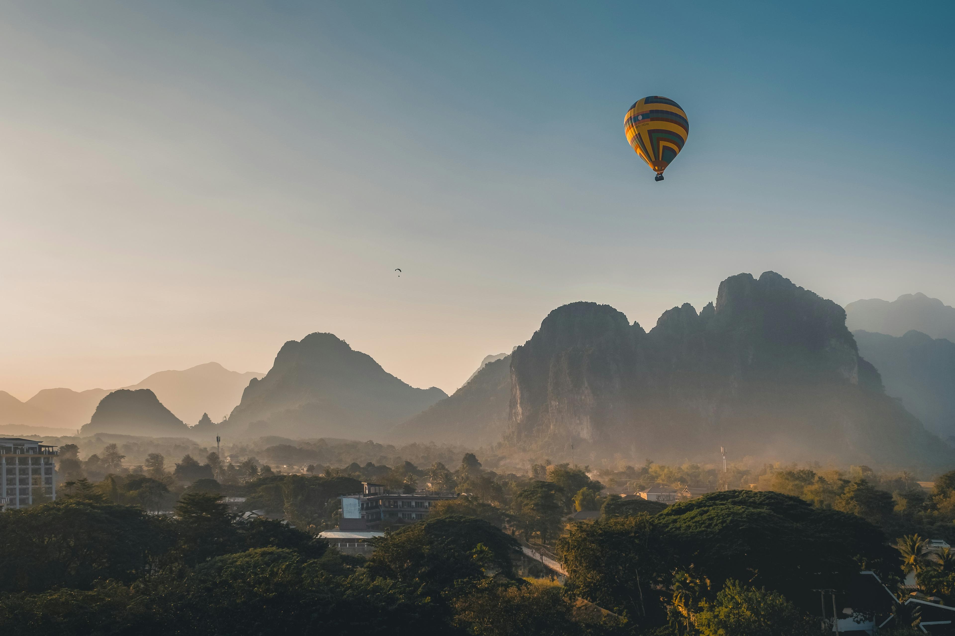 Vang Vieng, Laos — hot air balloon over karst mountains at sunrise